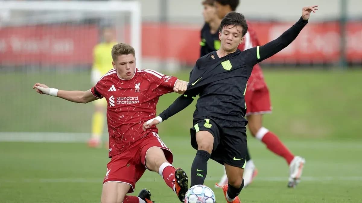 Liverpool player challenges opponent during match action