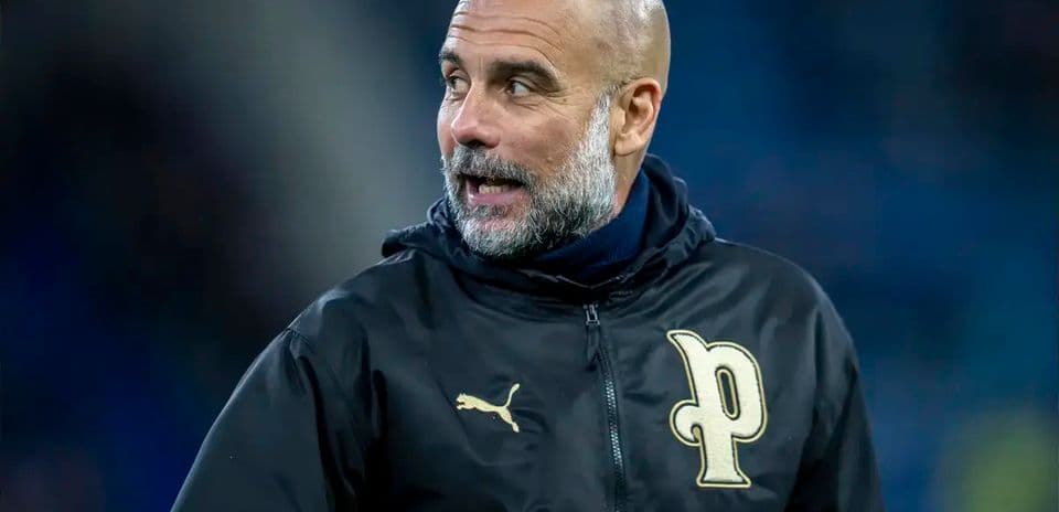 Football coach wearing team jacket on the pitch