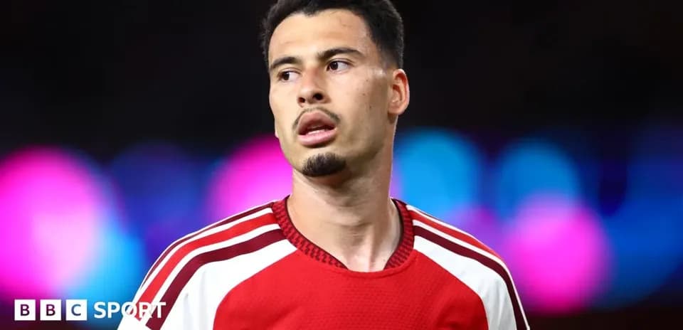 Futbolçu Arsenal formasında mavi fon arxasında