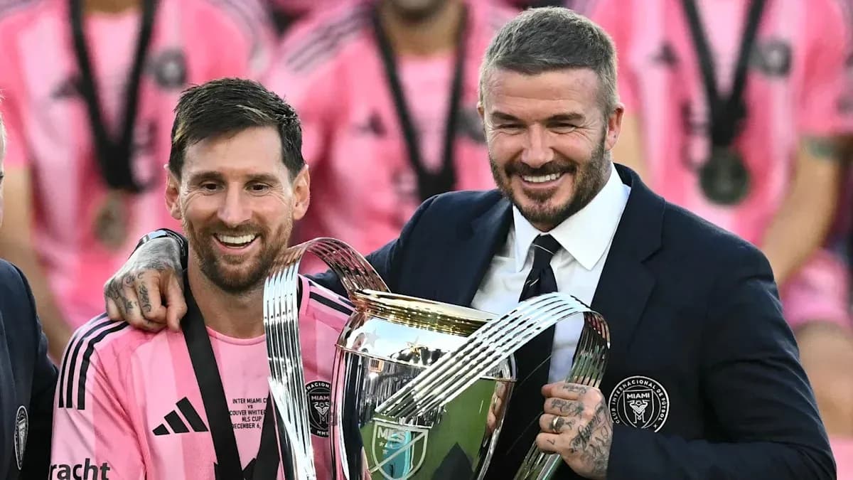 Messi and Beckham celebrating with trophy after match