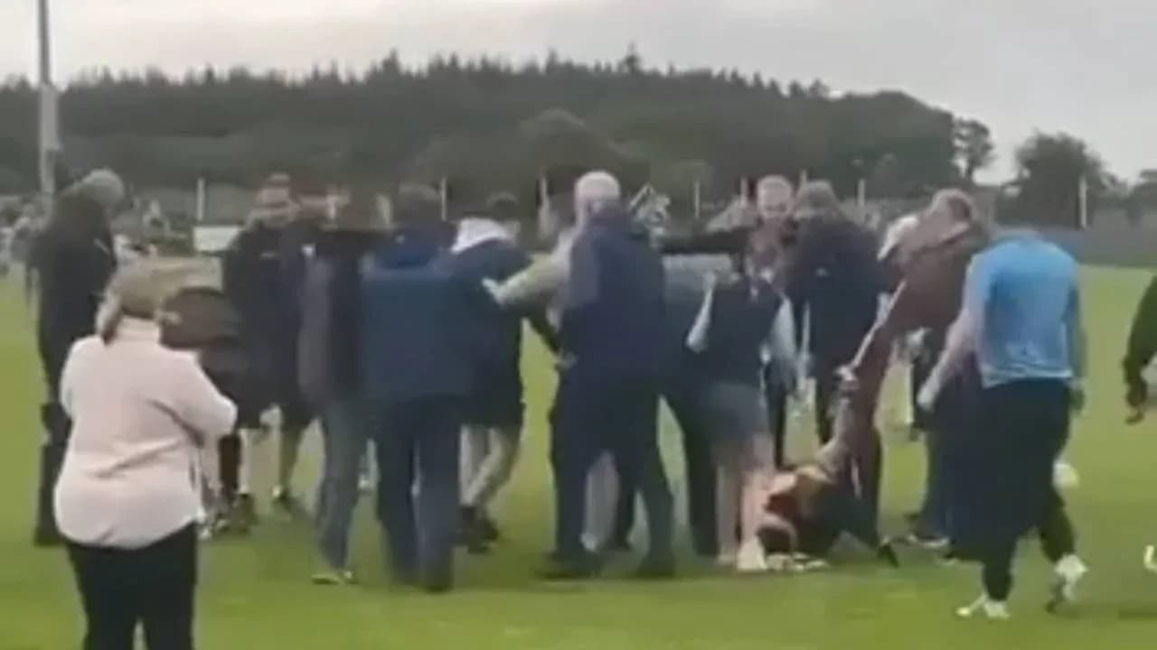 Crowd surrounding players on the field after match