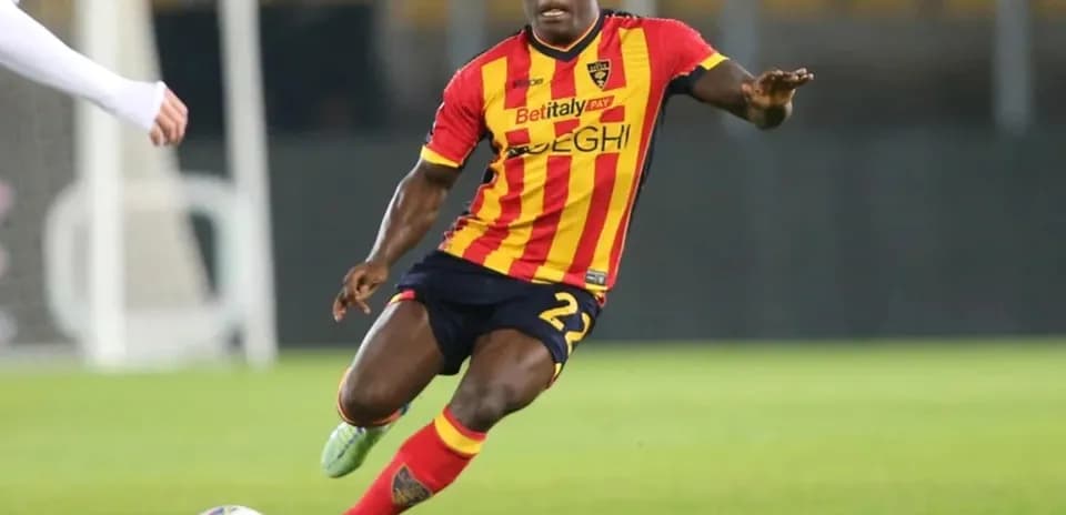 Futbolçu topa doğru sürətlənir, forma sarı-qırmızı