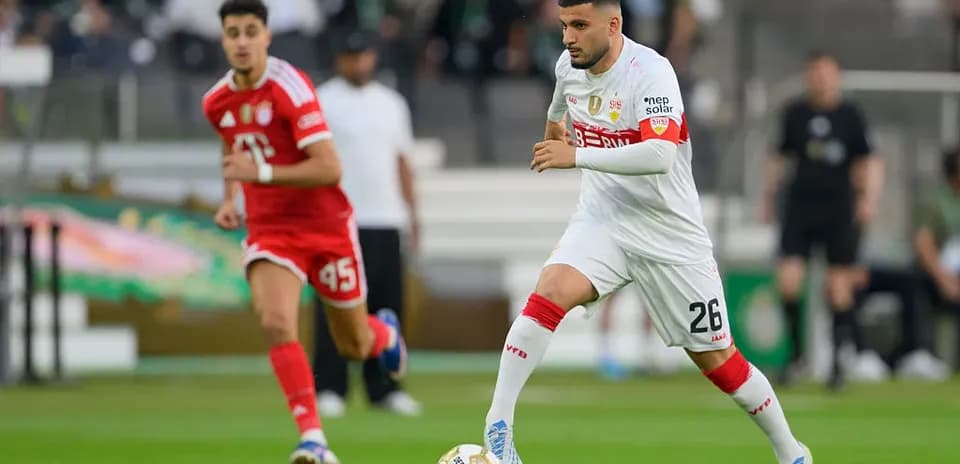 İki futbolçu meydanda top üçün mübarizə aparır