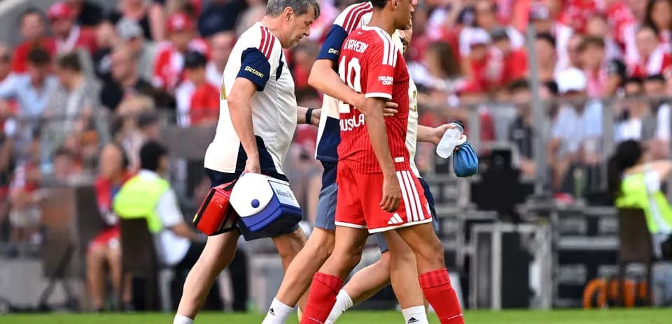 Player being assisted off the pitch by medical staff