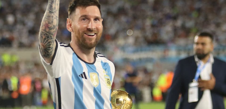 Lionel Messi holding World Cup trophy in stadium