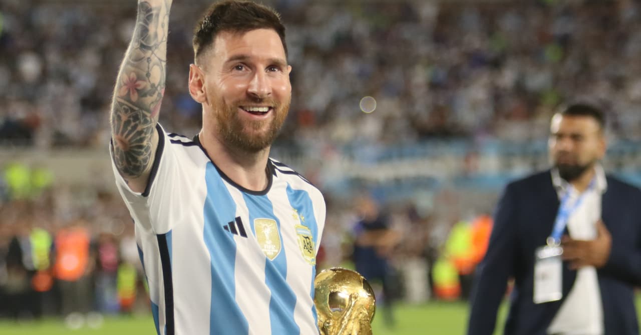 Lionel Messi holding World Cup trophy in stadium