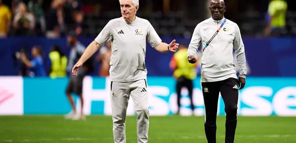 Two coaches walking on the pitch during match