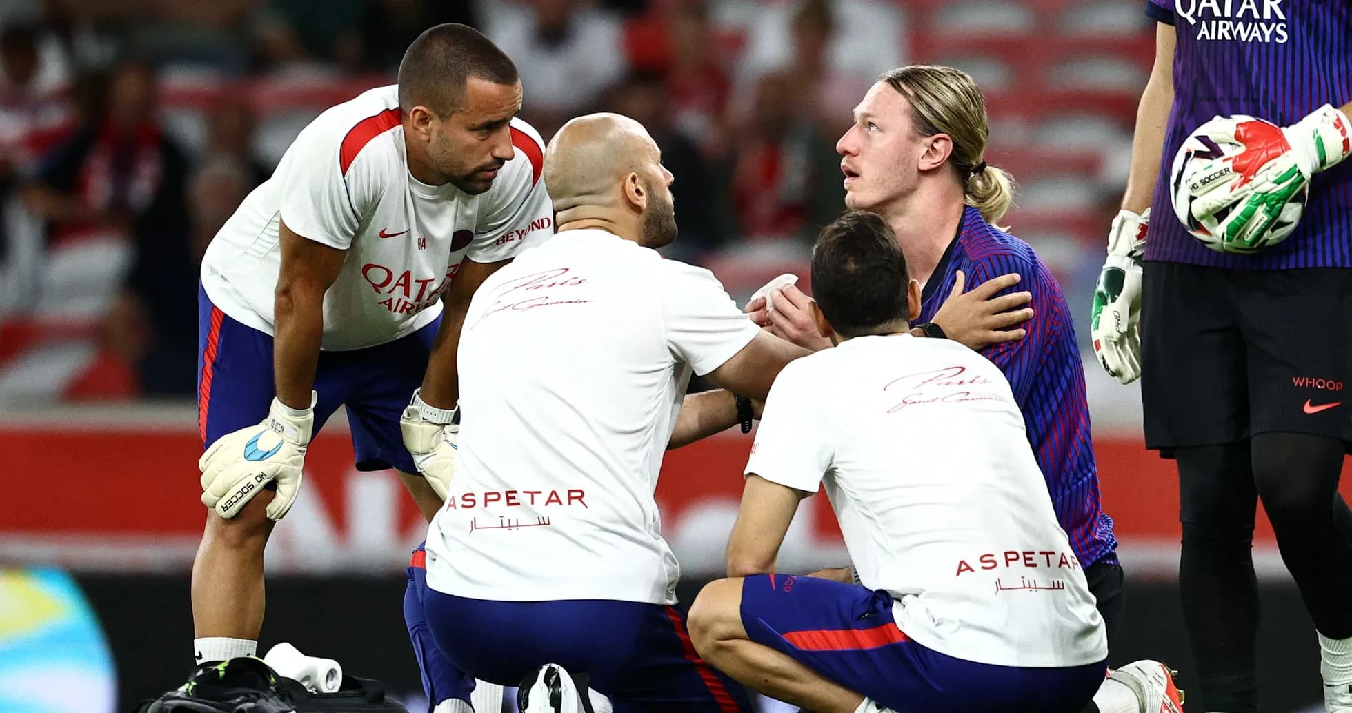 Goalkeeper receiving medical attention from team staff