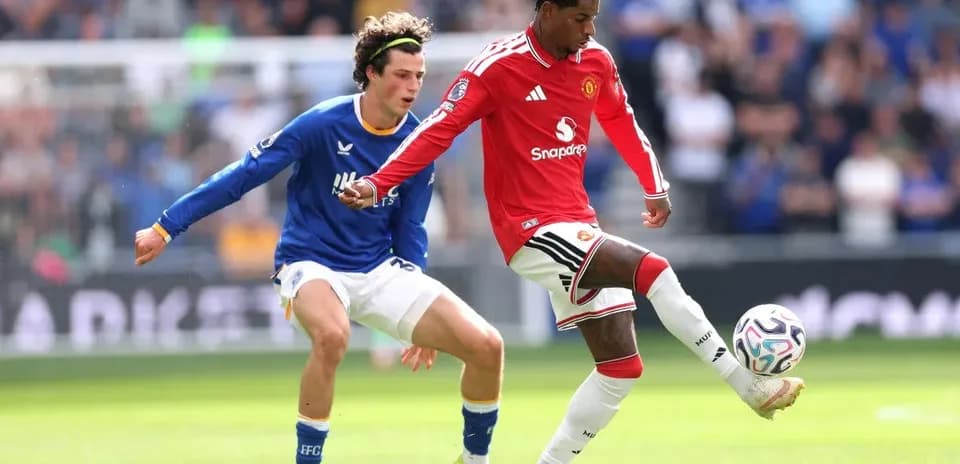 Manchester United player dribbling past Everton opponent