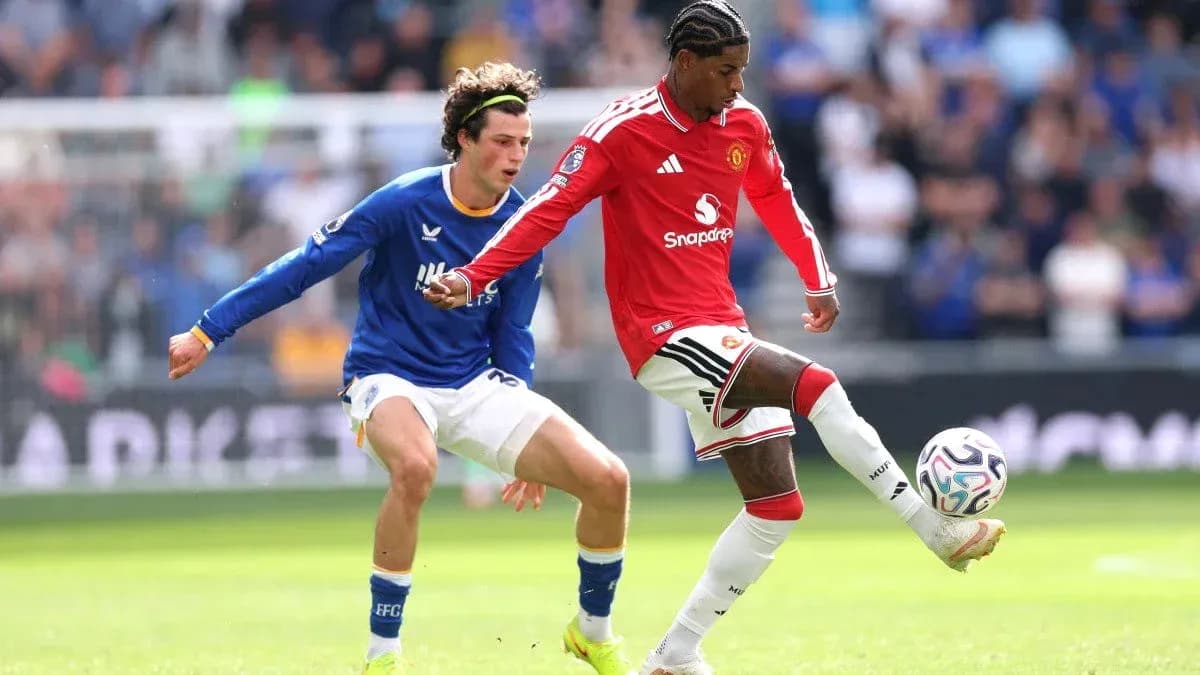 Manchester United player dribbling past Everton opponent