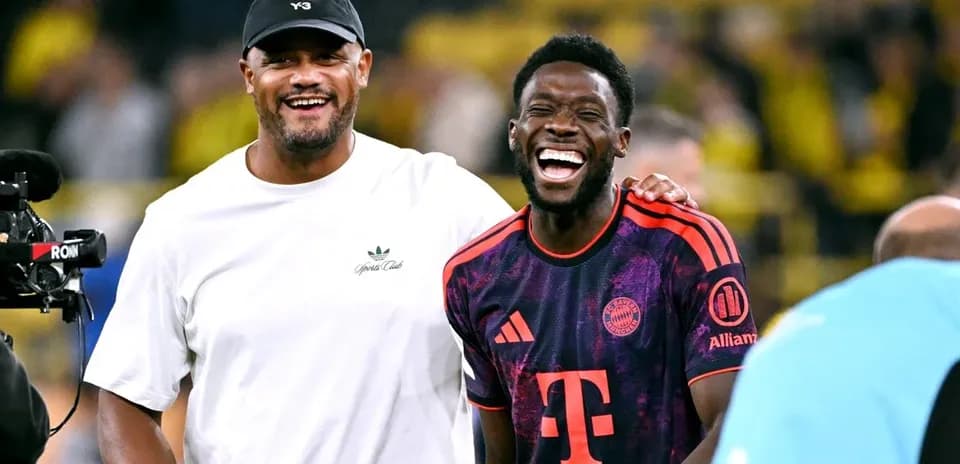 Two men laughing on the football pitch after match