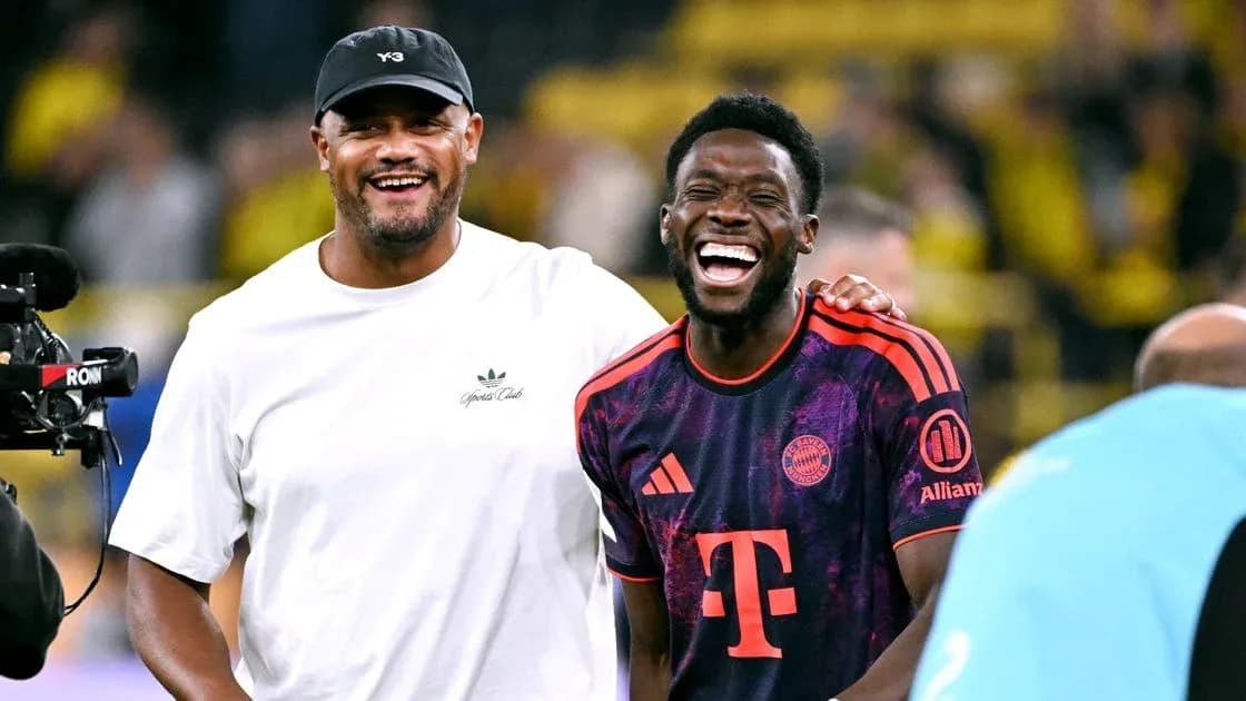 Two men laughing on the football pitch after match