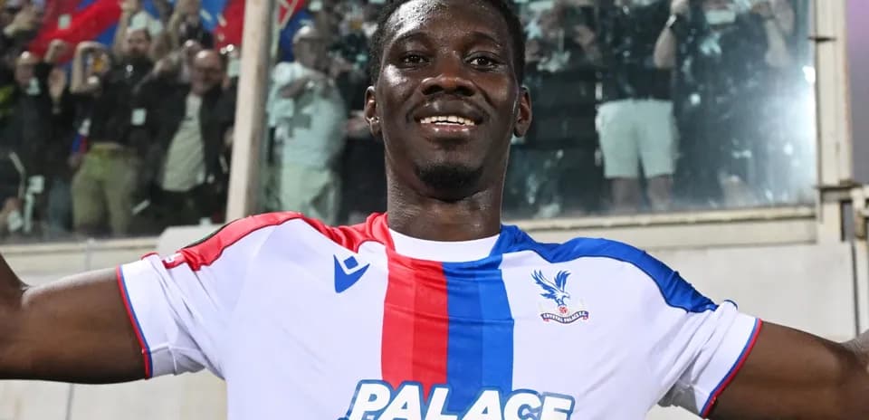 Futbolçu Crystal Palace formasında gülərək poz verir