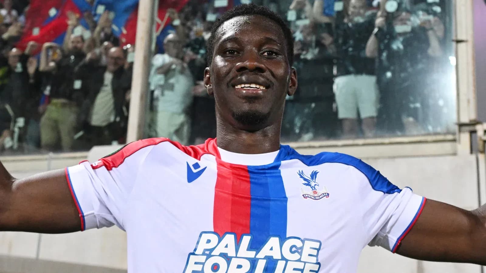 Futbolçu Crystal Palace formasında gülərək poz verir