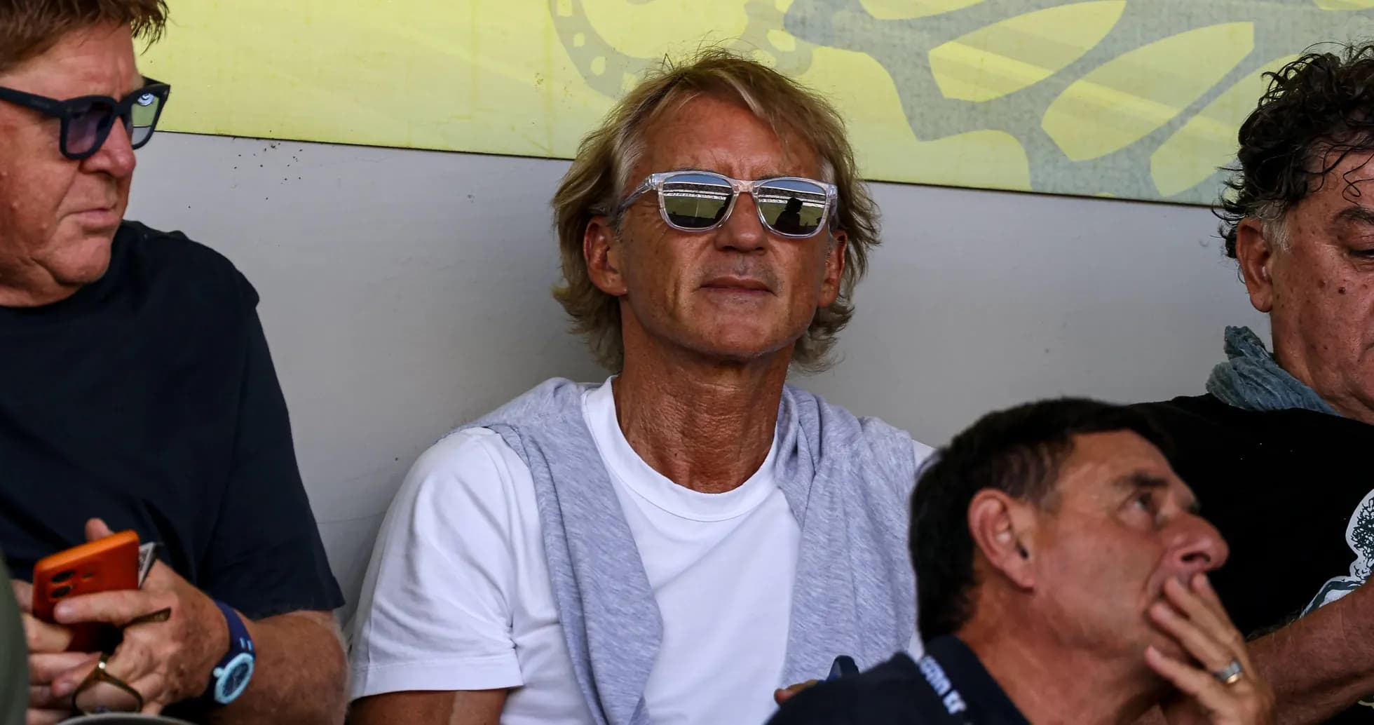Man wearing sunglasses sitting in a crowd