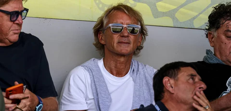 Man wearing sunglasses sitting in a crowd