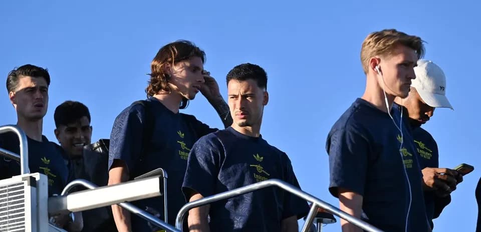Players descending stairs in team attire outdoors