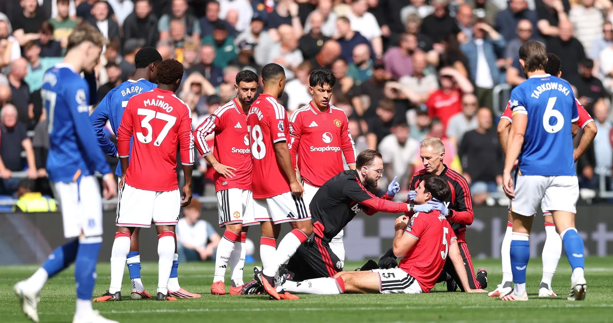 Players gathered around injured teammate on pitch