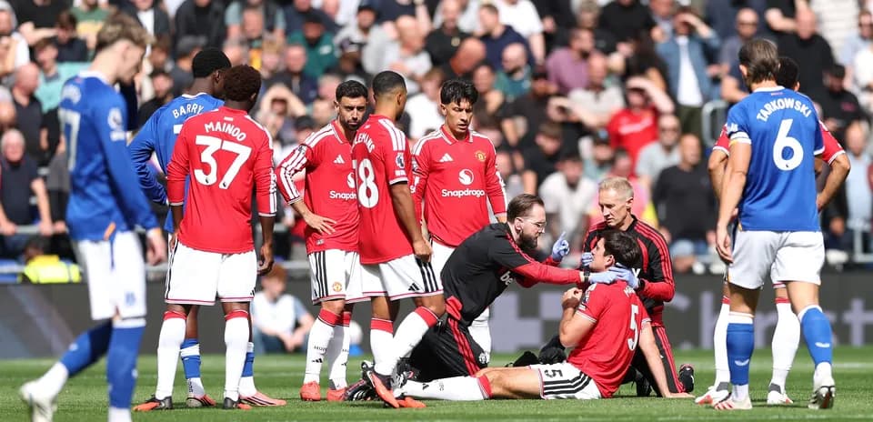 Players gathered around injured teammate on pitch