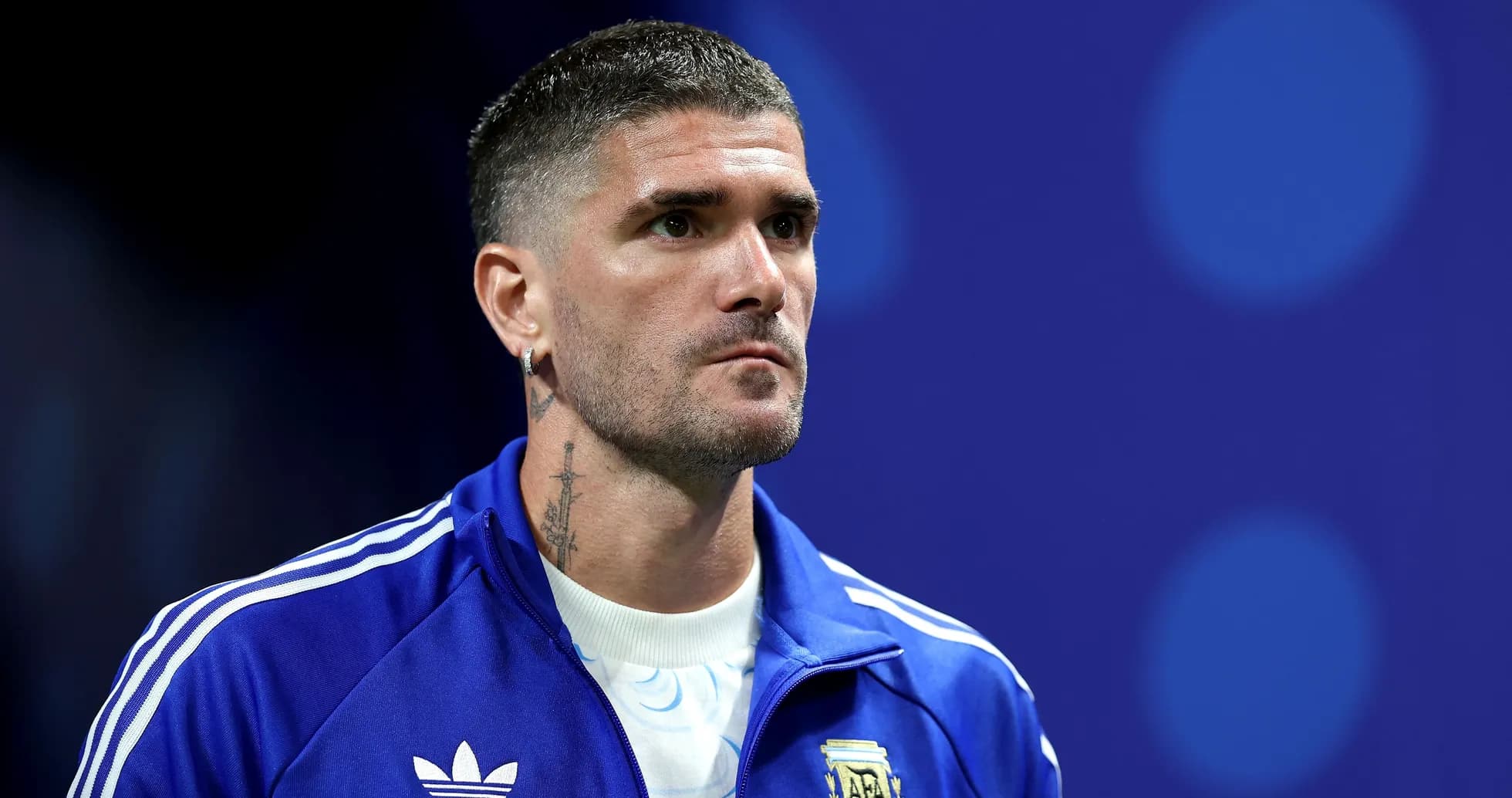 Futbolçu mavi forma ilə mətbuat konfransında