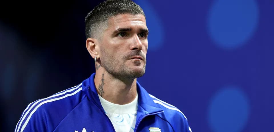 Futbolçu mavi forma ilə mətbuat konfransında