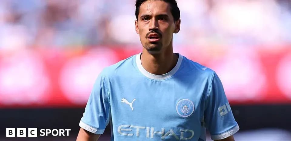 Futbolçu mavi forma ilə meydanda dayanır