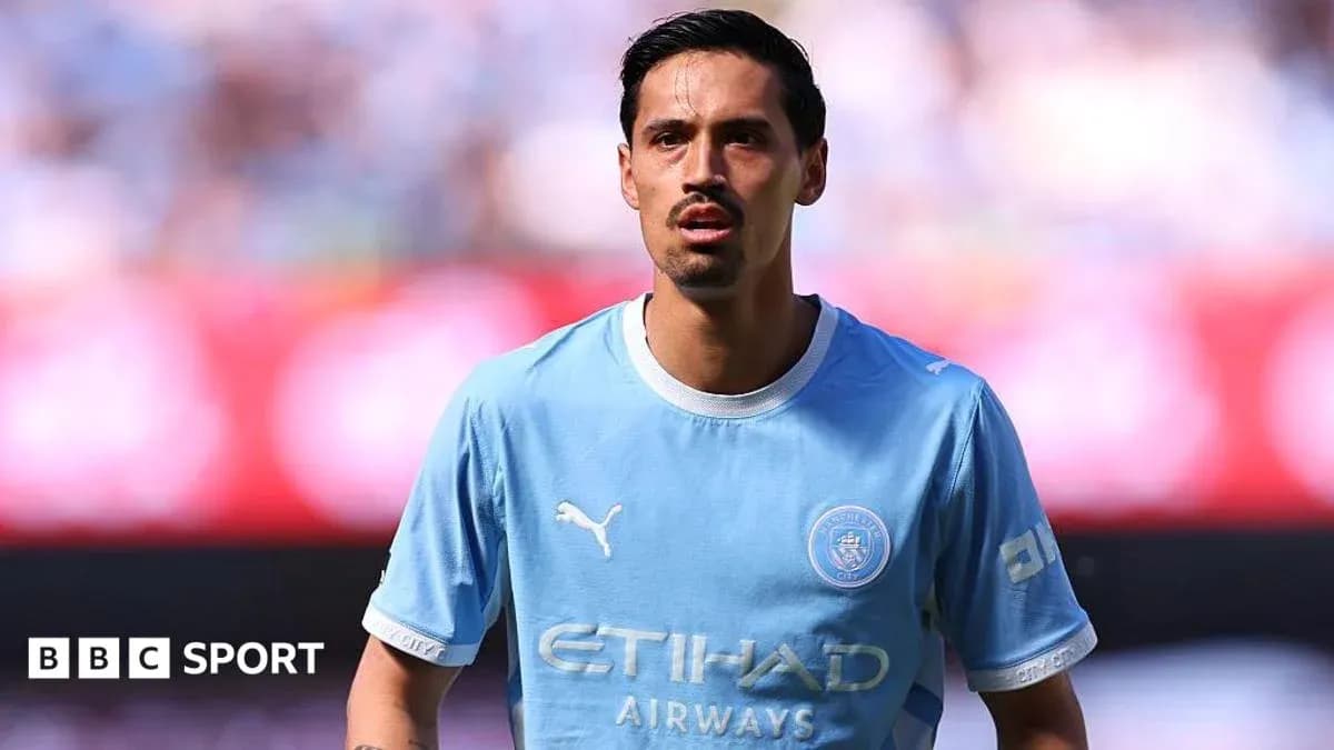 Futbolçu mavi forma ilə meydanda dayanır
