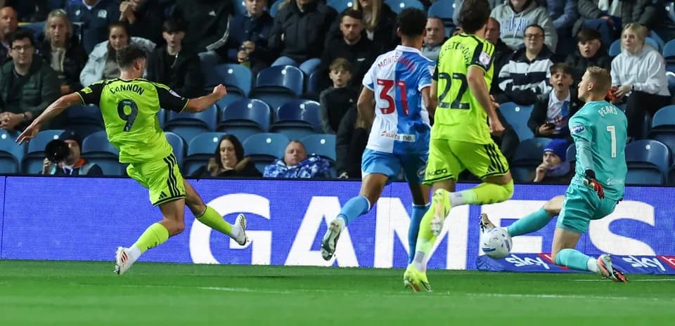 Player shooting at goal with goalkeeper approaching