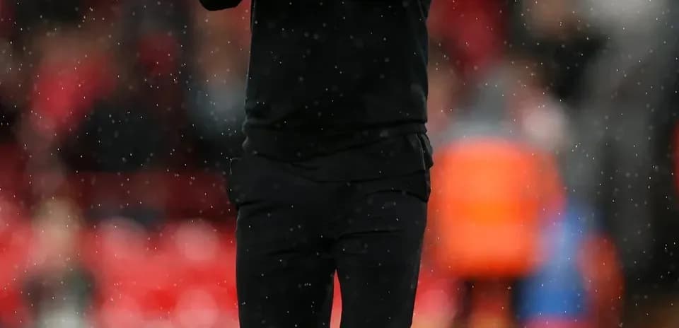 Coach applauding on the pitch during a match