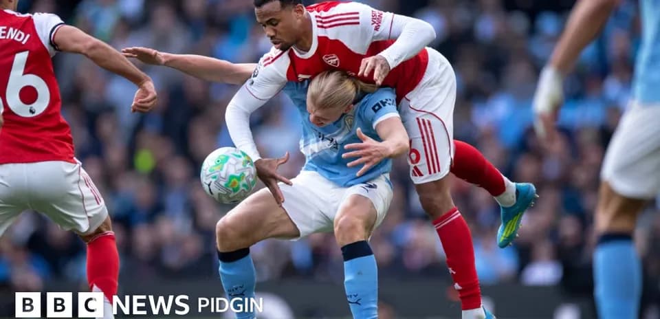 Arsenal player tackling Manchester City player during match