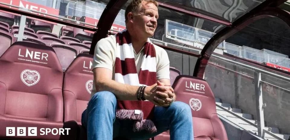Men sitting on team bench wearing club scarf