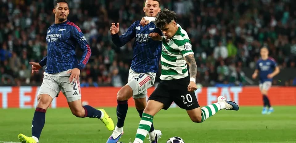 Celtic player kicking ball while challenged by opponents