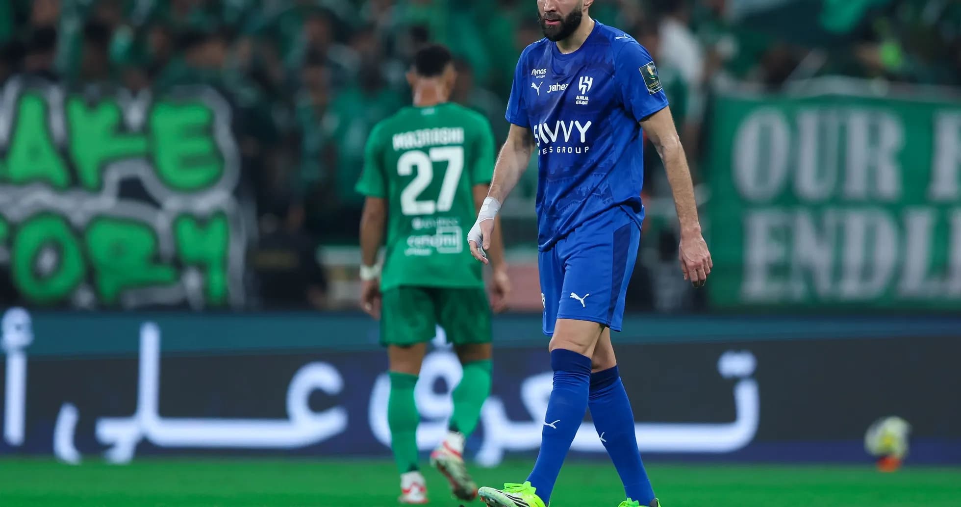 Player in blue kit walking on the pitch during match