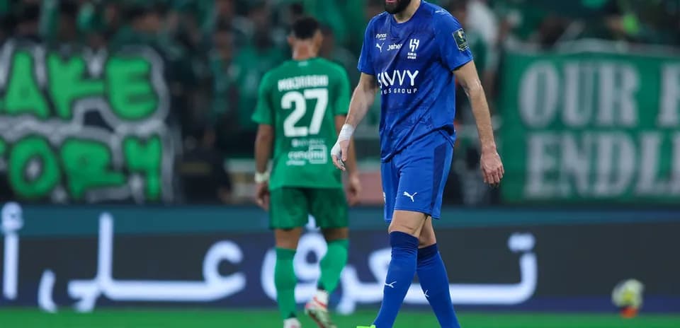 Player in blue kit walking on the pitch during match
