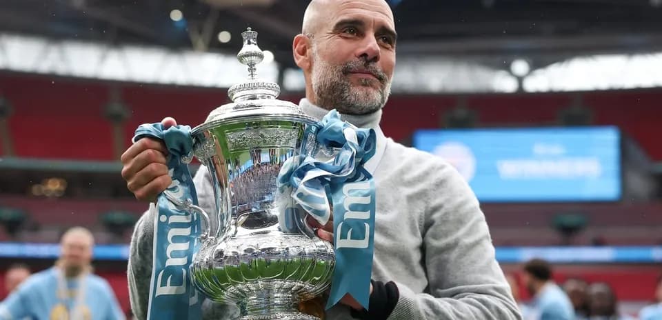 Men's football manager holding trophy at Wembley