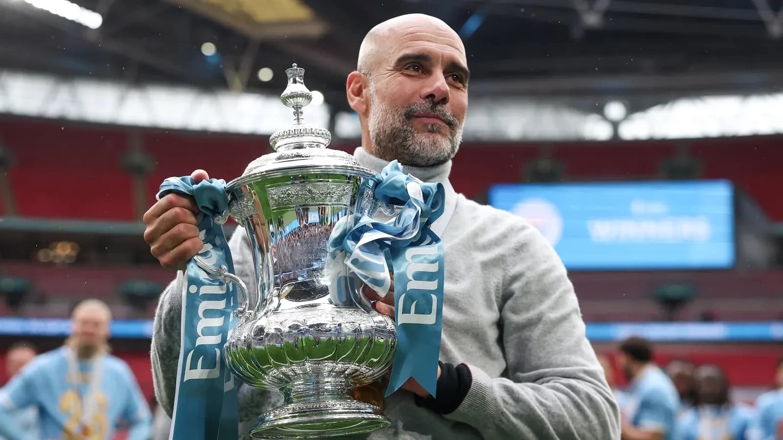 Men's football manager holding trophy at Wembley