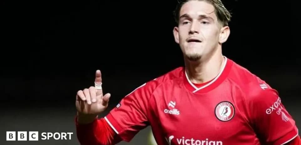 Futbolçu qolu qeyd edir, qırmızı forma geyinib