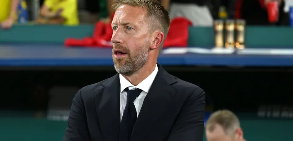 Men's football coach observing match from sidelines