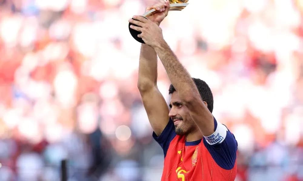 Futbolçu qızıl kuboku havada tutaraq sevinir
