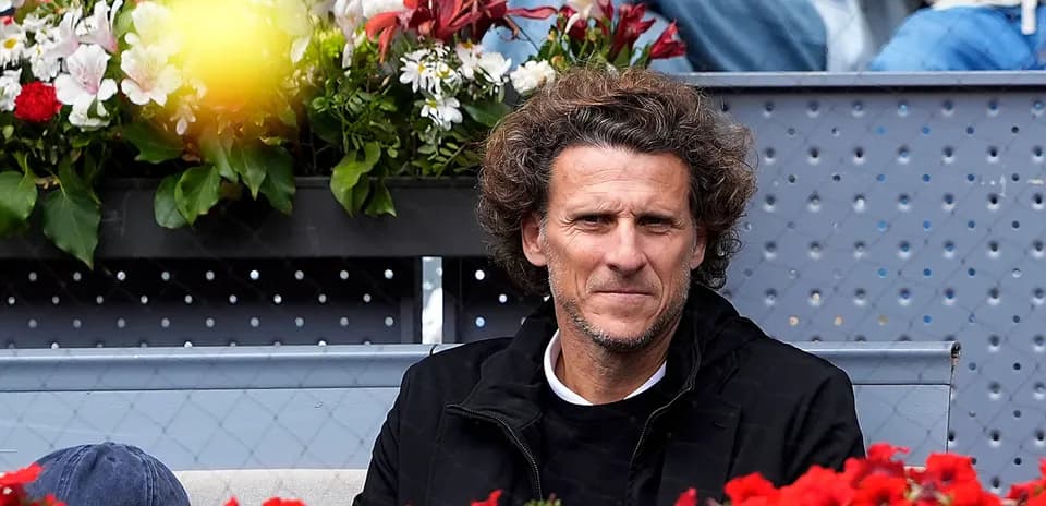 Spectator seated among flowers at tennis event