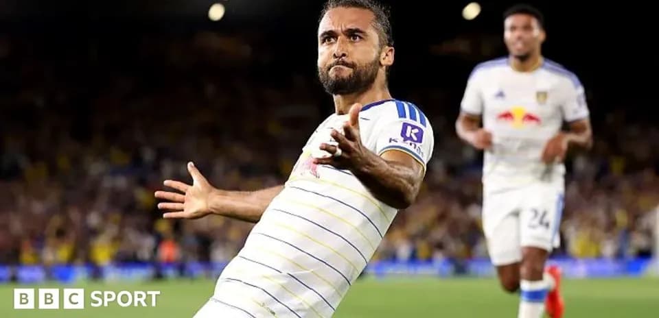 Player celebrating goal with teammates in stadium
