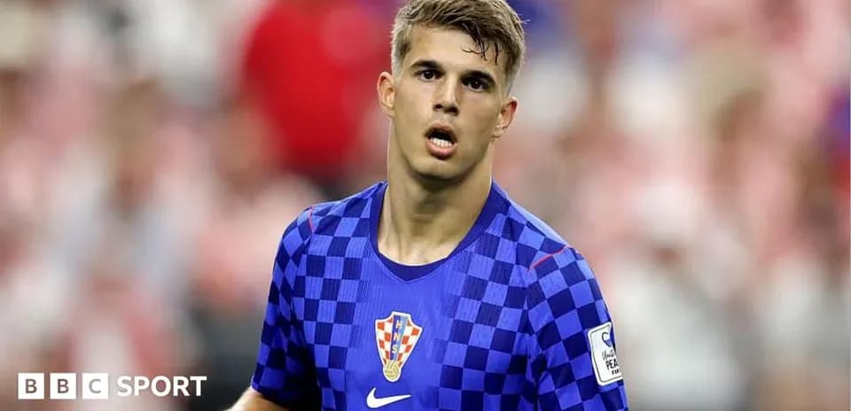 Futbolçu mavi çəhrayı forma ilə meydanda