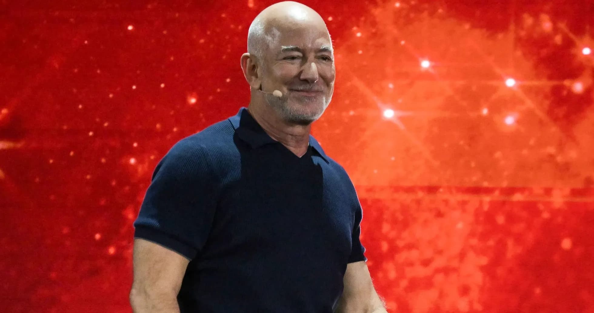Speaker presenting on stage with red background