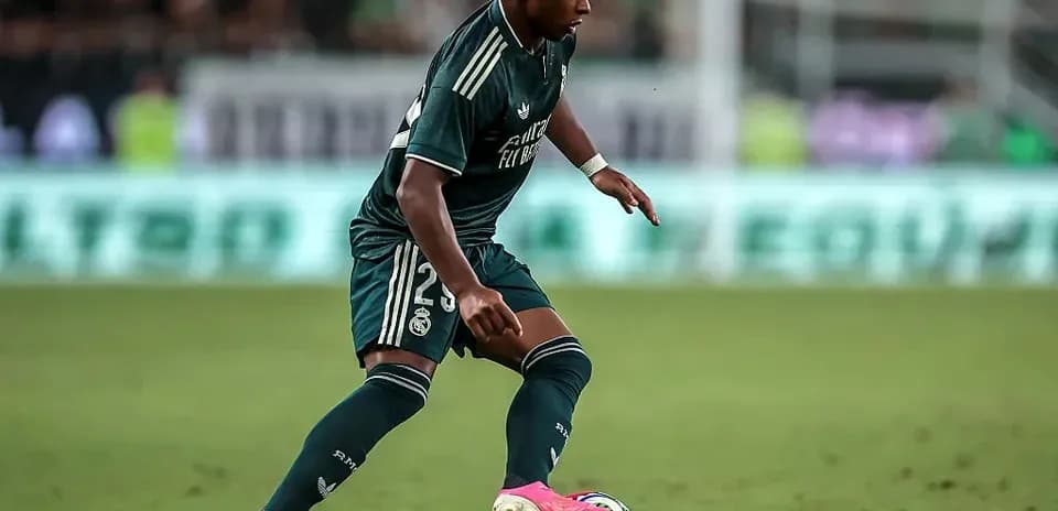 Futbolçu topu idarə edərək irəliləyir