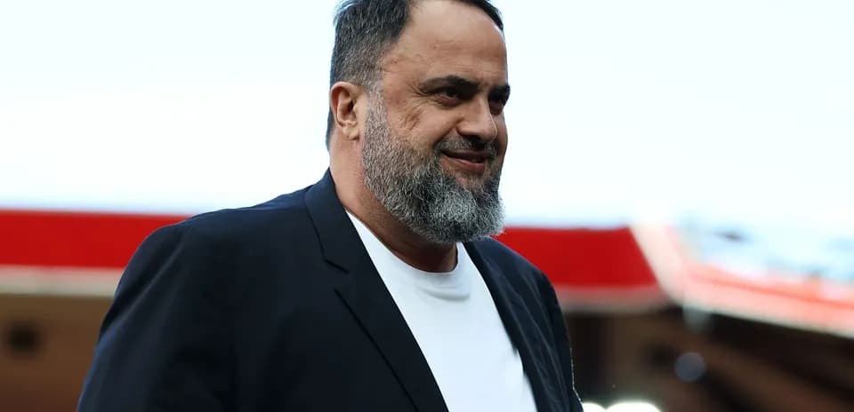 A man walking in a black suit and white shirt