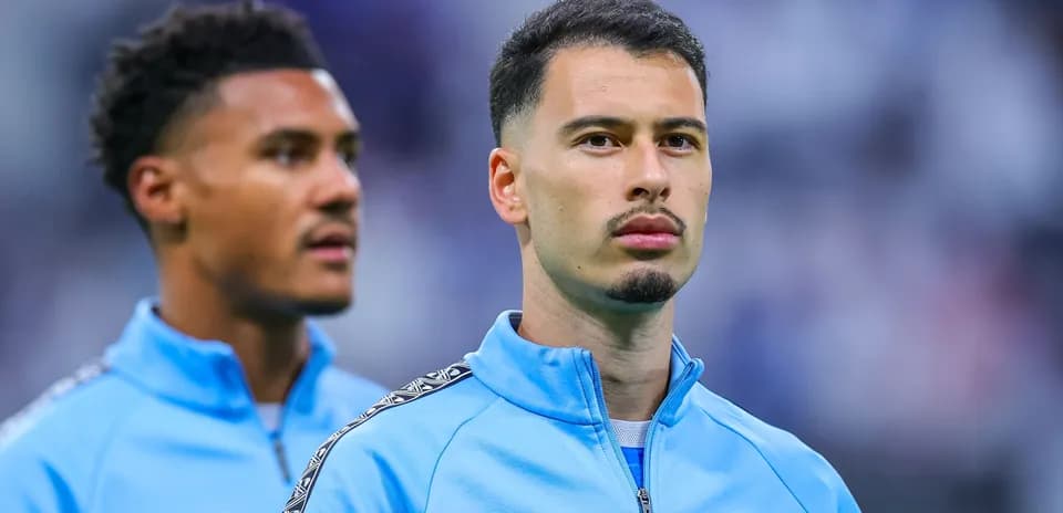 İki futbolçu mavi idman geyimində durur