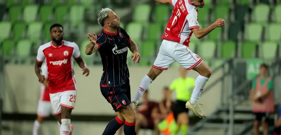 FK Crvena Zvezda futbolçusu topa zərbə vurur