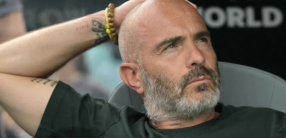 Coach resting on bench during match