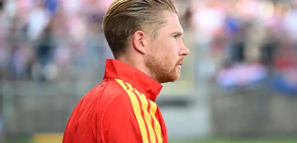 Futbolçu qırmızı forma ilə yan profildən