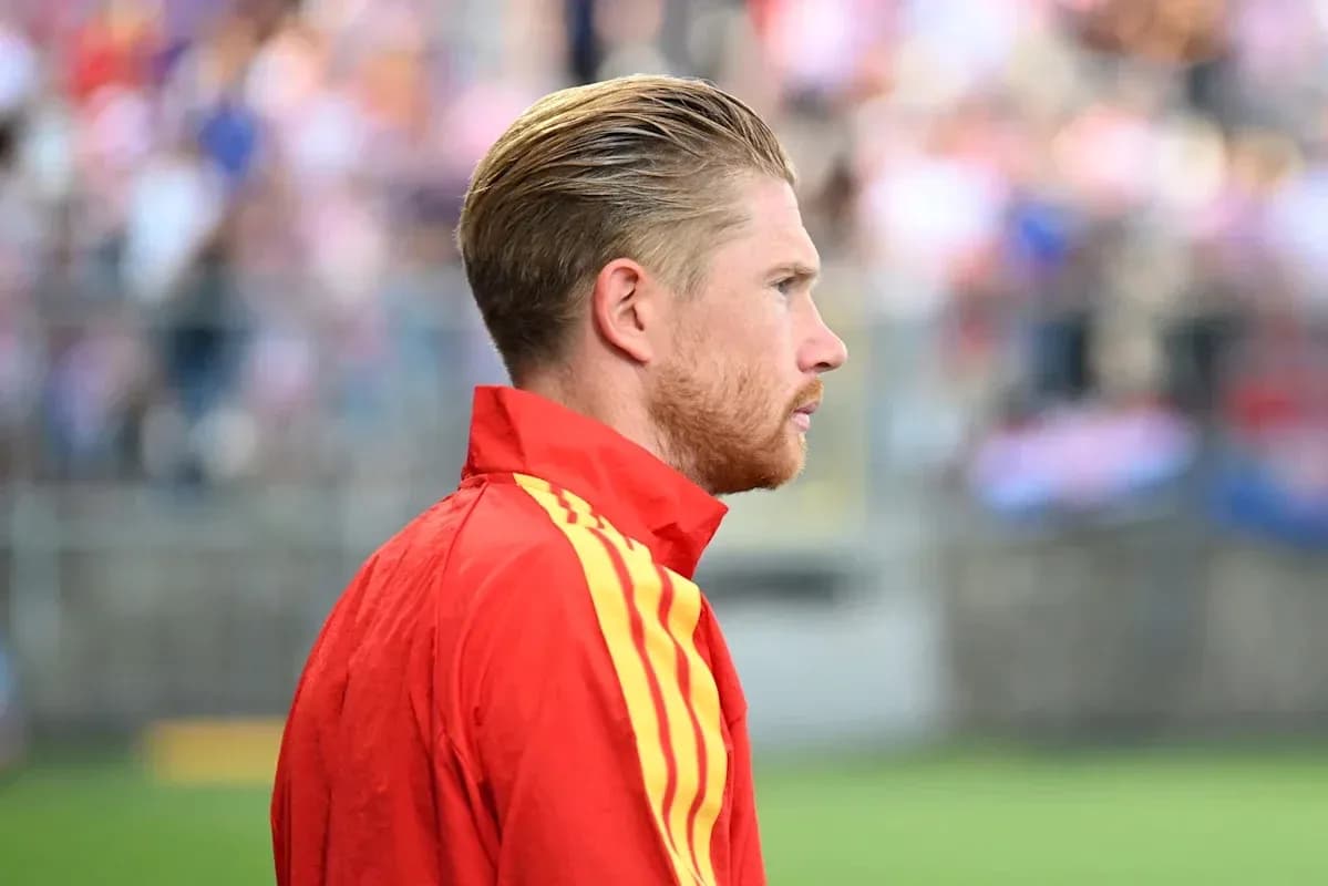 Futbolçu qırmızı forma ilə yan profildən